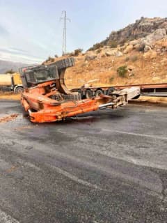 Adıyaman Kahta ilçesinde tırdan düşen paletli kepçe yolda devrilmiş halde