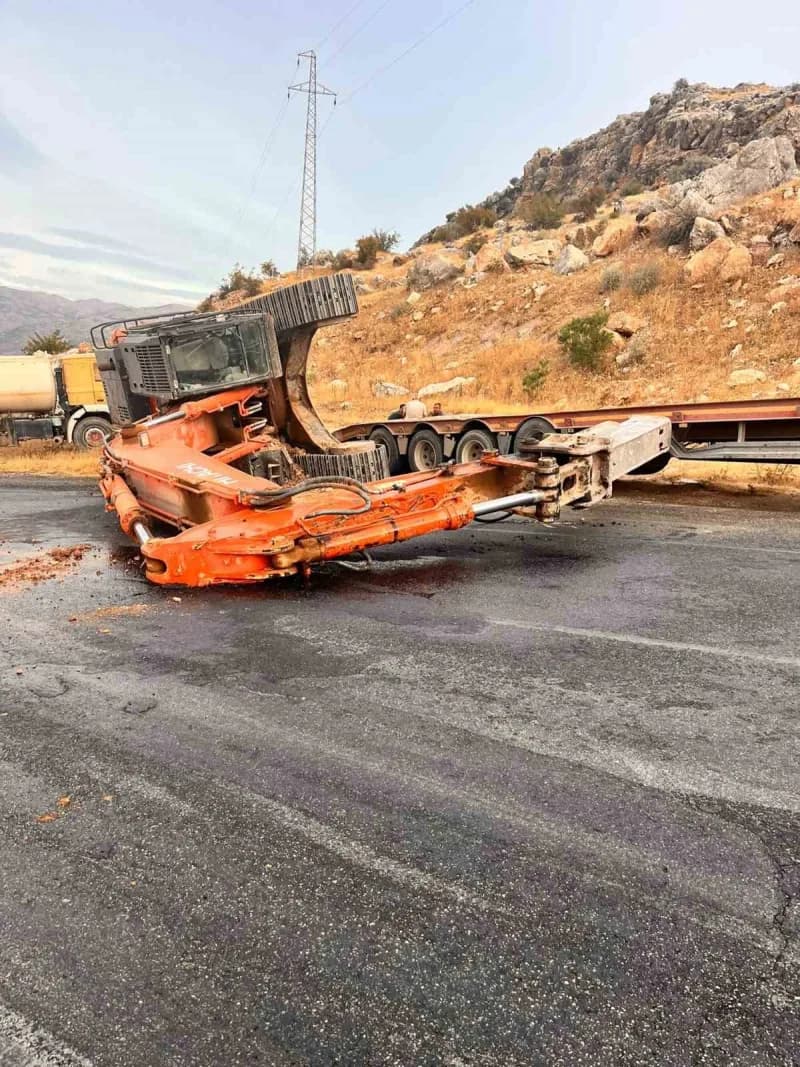 Adıyaman Kahta ilçesinde tırdan düşen paletli kepçe yolda devrilmiş halde