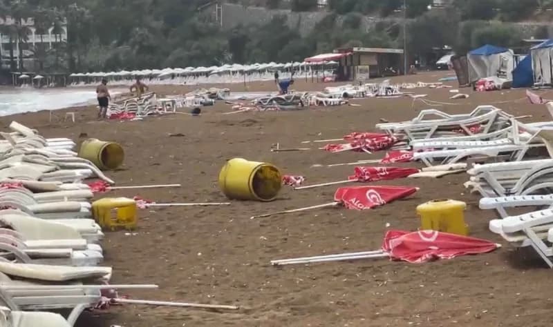 Alanya İncekum Plajı’nda şiddetli rüzgar nedeniyle sahilde savrulan şezlonglar ve şemsiyeler