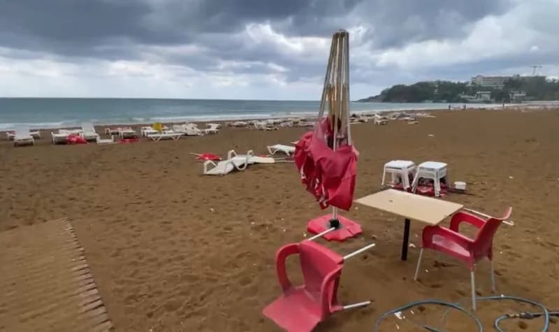 Alanya ilçesinde sabah saatlerinde etkili olan şiddetli rüzgar, plajda şezlongları yerinden sürükledi.