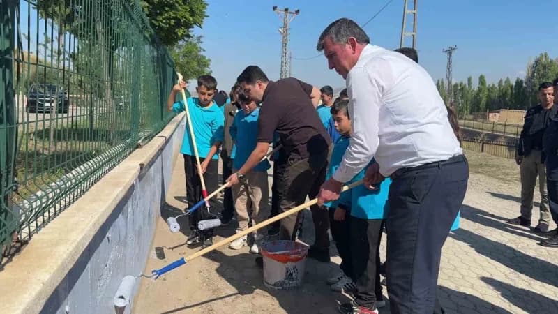 Altınyayla Şehit Zekeriya Demirkaynak Ortaokulu bahçesinde öğrenciler ve yöneticiler duvar boyama ve çevre temizliği yap