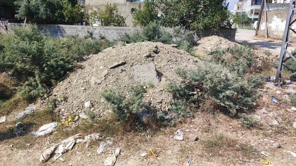 Adana Seyhan Küçükdikili Mahallesi'nde altyapı çalışması sonrası boş arazide biriken asfalt ve toprak atıkları