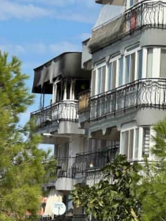 Ayvalık'ta 5 katlı binanın en üst katındaki dairede çıkan yangına itfaiye ekipleri müdahale ediyor