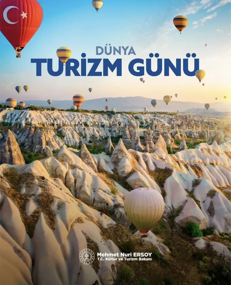 Kapadokya'da peribacaları ve gökyüzünde sıcak hava balonları manzarası, Dünya Turizm Günü afişi ile birlikte