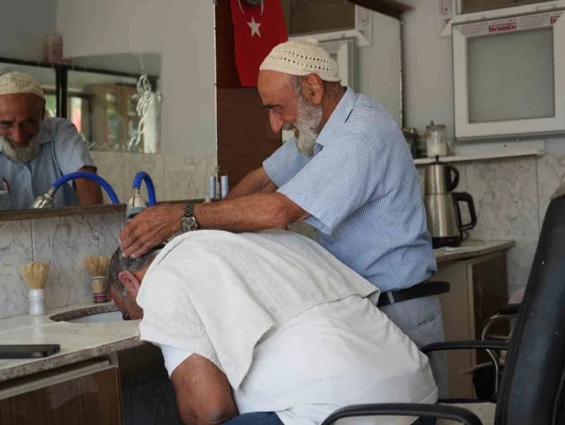 Abdulkadir Aksoy, 65 yıldır berberlik mesleğini sürdürerek müşterilerini tıraş ediyor.