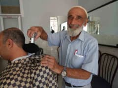 Gaziantep Oğuzeli'nde 65 yıldır berberlik yapan 76 yaşındaki Abdulkadir Aksoy dükkanında müşterilerini tıraş ediyor