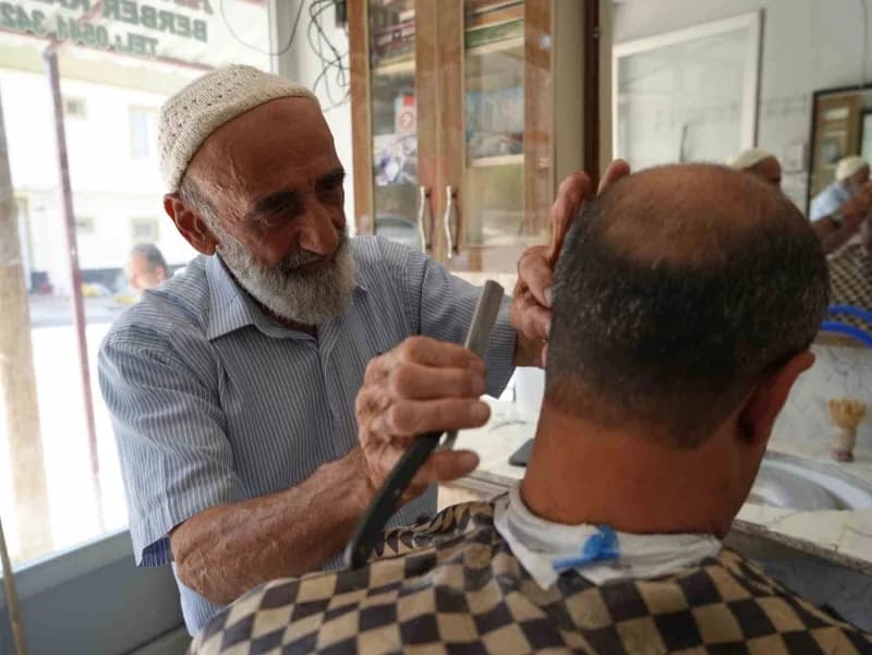 Abdulkadir Aksoy, 65 yıldır berberlik mesleğini sürdürerek müşterilerini tıraş ediyor.