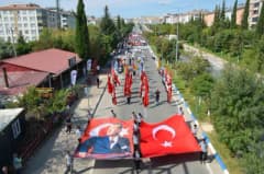 Adıyaman Besni'de 28. Eğitim Bayramı yürüyüşü ve açılış töreninden katılımcılar Türk bayraklarıyla yürürken