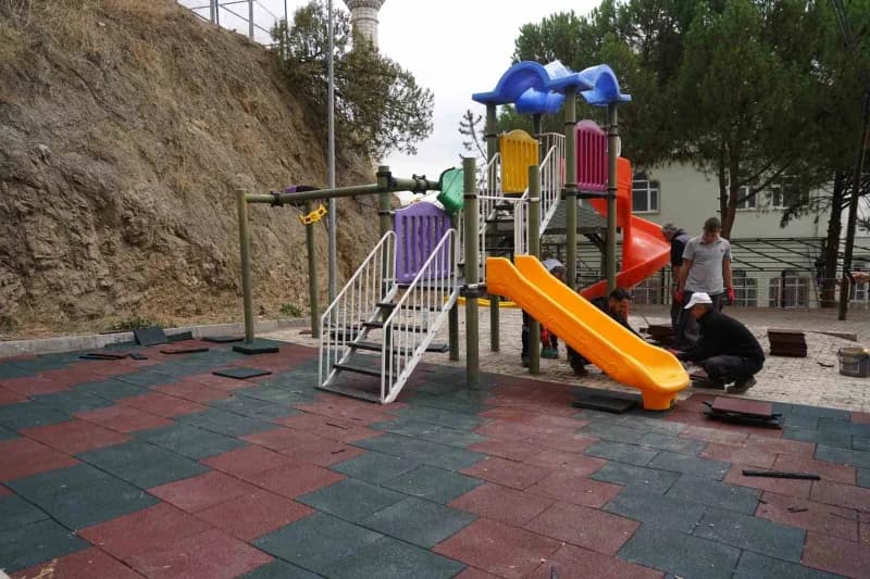 Bilecik kent merkezindeki çocuk parkında kauçuk zemin yenileme çalışması yapan belediye ekipleri