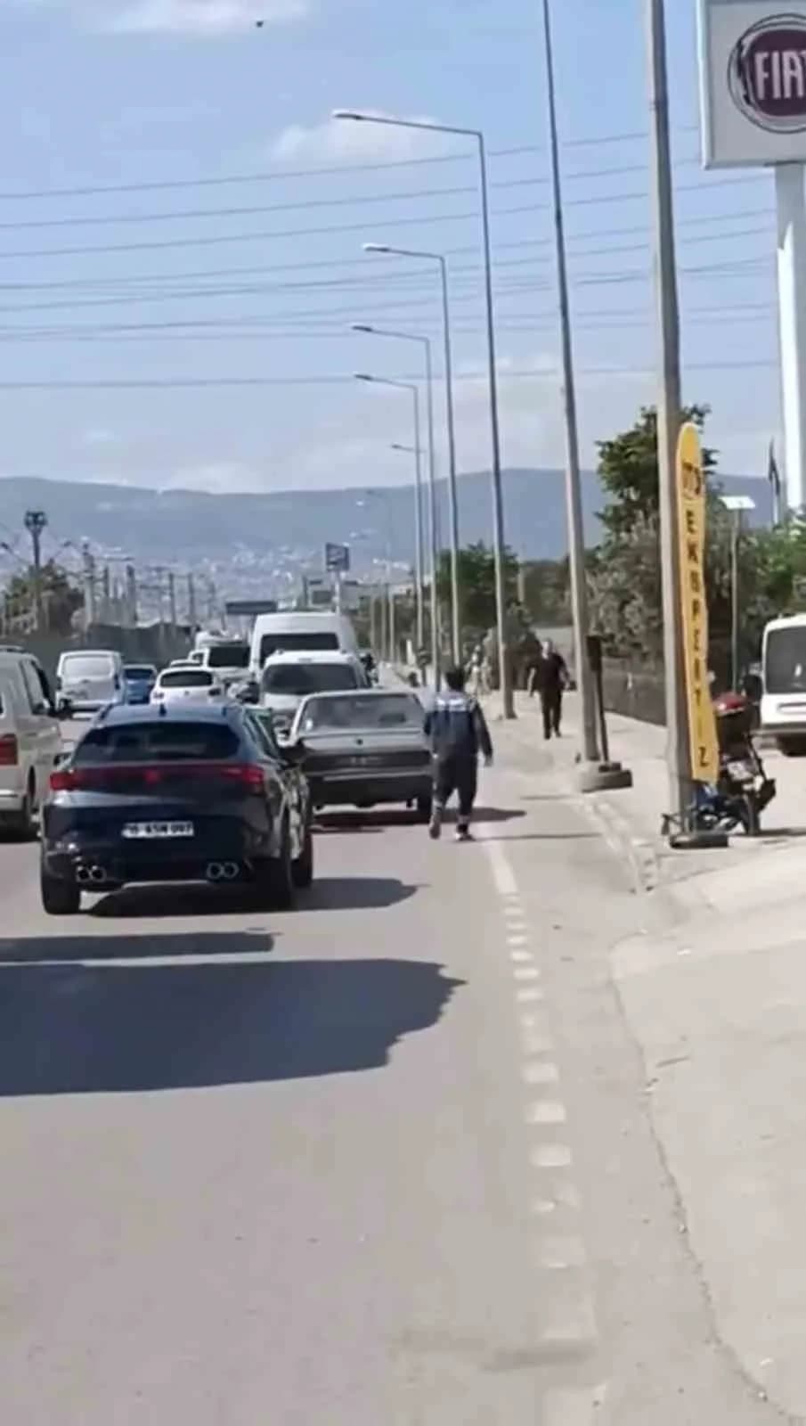 Bursa’da motokuryeden arızalanan otomobili itmek için ilginç yöntem
