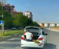 Diyarbakır Yenişehir ilçesinde seyir halindeki otomobilin bagaj kapısında oturan çocuk ve bagajda malzeme taşıyan kişi