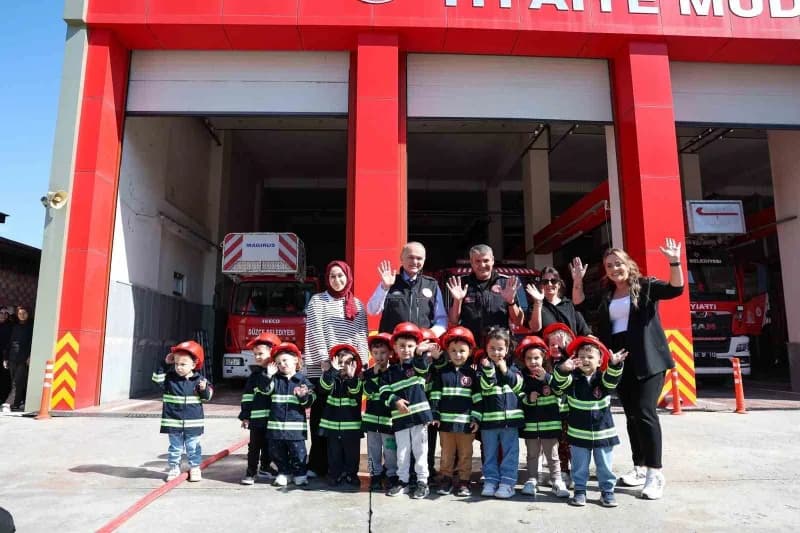 Düzce Belediye Başkanı Faruk Özlü itfaiye personeline tespih hediye ederken ve minik öğrencilerle yangın söndürme uygula