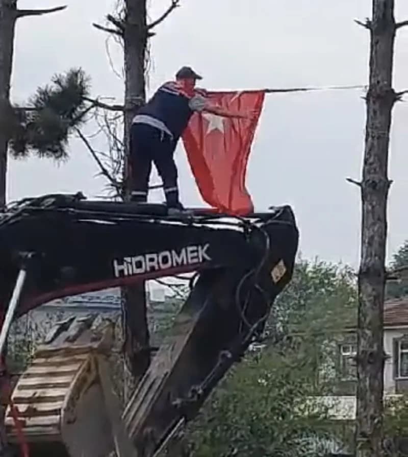 Düzce’de çalışma yaptığı sırada katlanan Türk bayrağı’nı fark ederek iş makinesinin üzerine çıkıp düzelten ekskavatör op