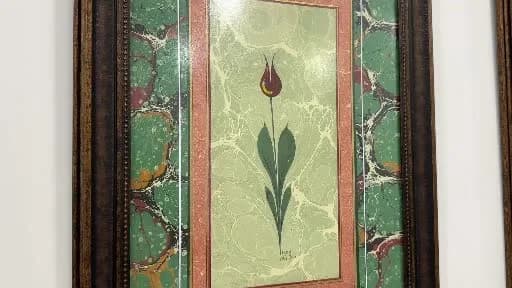 Hanife Cansever, ebru sanatıyla süslenmiş kişiye özel defterler yaparken atölyesinde çalışıyor