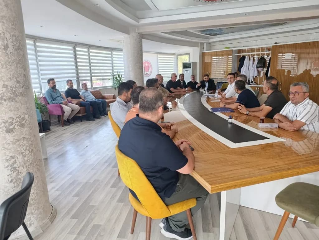 Mücahit Tekin okul idaresi ve öğretmenlerle toplantı masasında görüşüyor