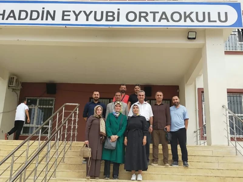 Selahaddin Eyyubi Ortaokulu merdivenlerinde kadın ve erkek öğretmenlerle ziyaret ekibi