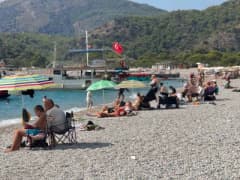 Fethiye Ölüdeniz sahilinde yazdan kalma sıcak havada denize giren ve güneşlenen turistler