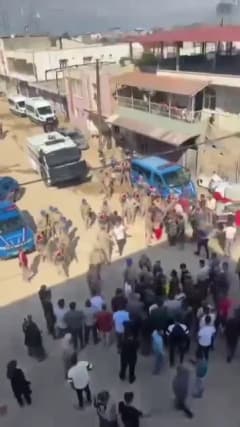 Hatay Reyhanlı Harran Mahallesi'nde kaçak elektrik müdahalesi sırasında yolu kapatan mahalle sakinleri ve jandarma ekipl