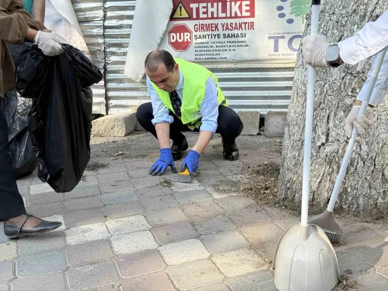 Iğdır Valisi M. Fırat Taşolar spatula ile ağaçların etrafındaki otları temizlerken