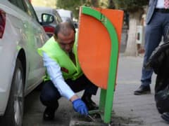 Iğdır Valisi M. Fırat Taşolar elinde fırça ve faraş ile çevre temizliği yaparken