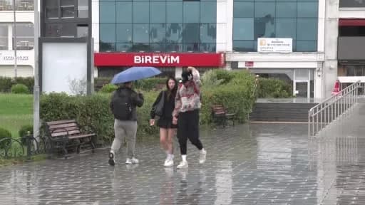 İstanbul Anadolu Yakası’nda etkili olan yağmur ve rüzgar nedeniyle sokakta yürüyen vatandaşlar