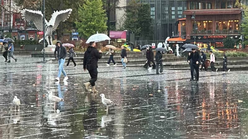 İstanbul’da sağanak yağış nedeniyle sokakta yürüyen vatandaşlar ve ıslak zemin