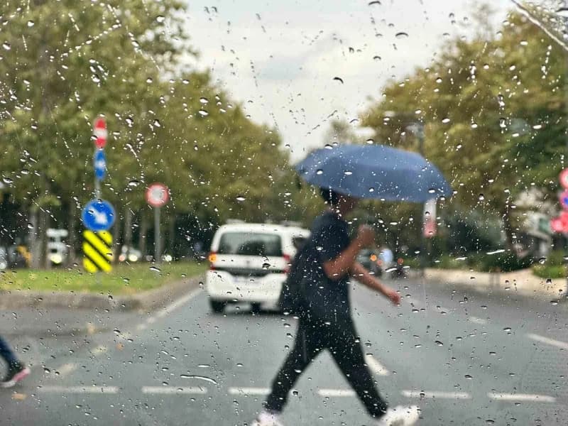 İstanbul’da sonbahar mevsiminde başlayan yağmur altında yürüyen ve duraklarda bekleyen vatandaşlar