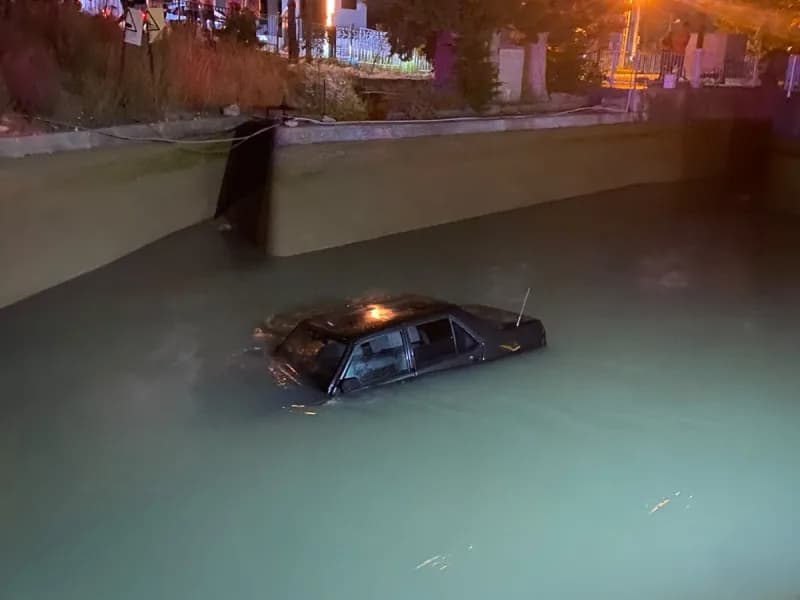 Mersin Silifke'de kanala düşen otomobilin vinçle kurtarılması sırasında aracın üzerine inen kişi halat takıyor
