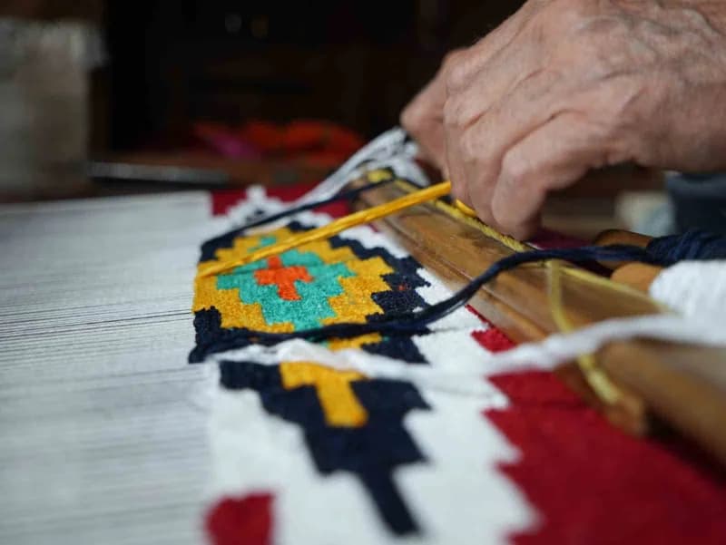 3 metrekarelik dükkanında dokuduğu kilimleri dünyaya gönderiyor