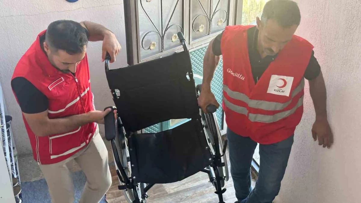 Türk Kızılay Muradiye Şubesi gönüllüleri ihtiyaç sahibi çocuklara giyim yardımı dağıtırken