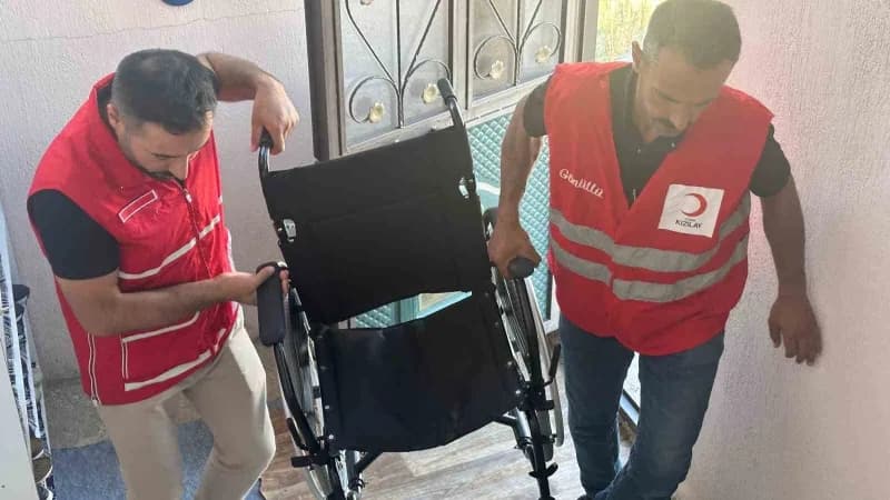 Türk Kızılay Muradiye Şubesi gönüllüleri ihtiyaç sahibi çocuklara giyim yardımı dağıtırken