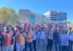 Konak Belediyesi önünde toplanan işçiler kırmızı kart göstererek eylem yapıyor