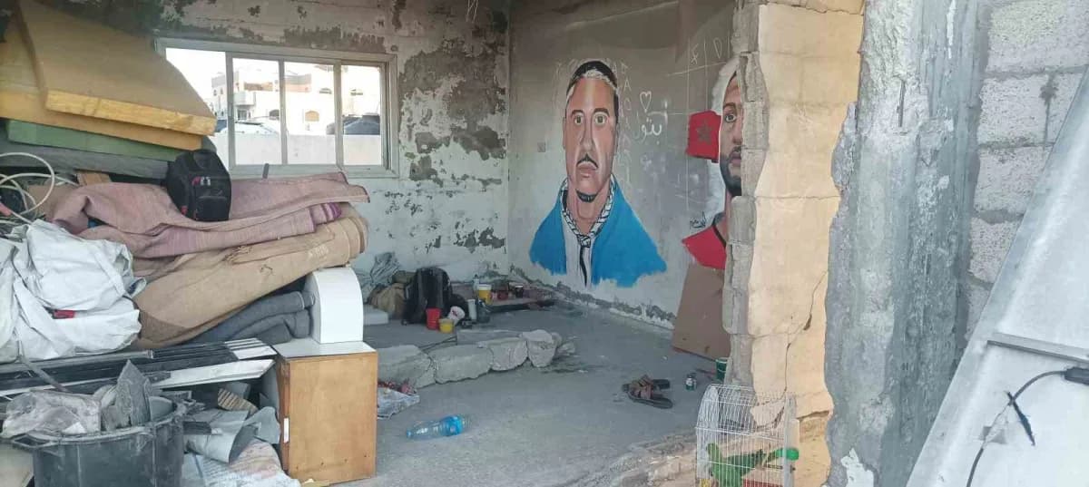 Gazze’de hasar gören binanın duvarına ABD’li rapçi Macklemore’un resmini yapan Filistinli sanatçı Aby Qershala