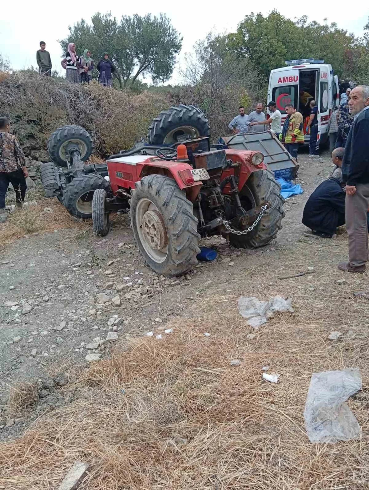 Manisa’nın Demirci ilçesinde tarla yolunda kontrolden çıkarak devrilen traktörün altında kalan 2 kişi hayatını kaybetti,