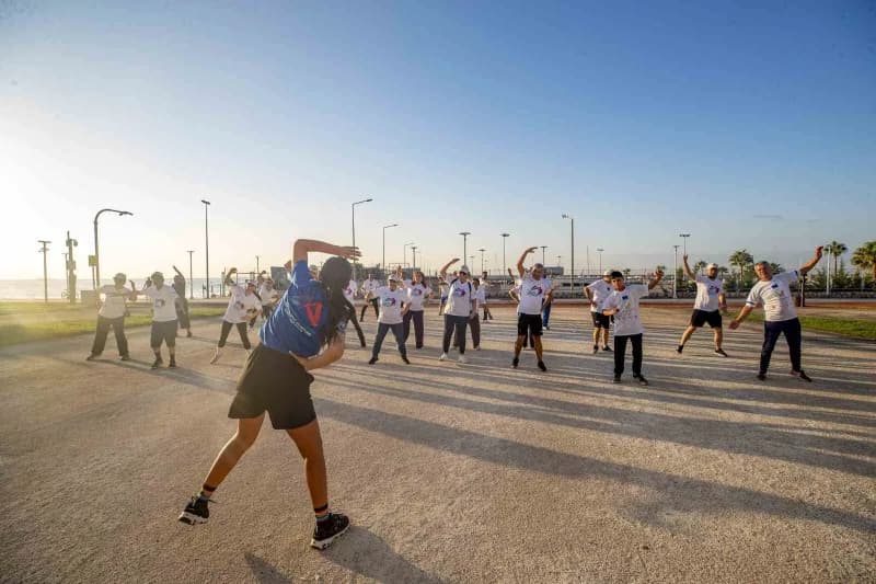 Mersin sahilinde sabah sporu yapan muhtarlar yürüyüş yapıyor