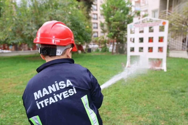 Manisa'da minik öğrenciler itfaiye araçları ve ekipmanlarını inceleyerek yangın söndürme eğitimi alıyor