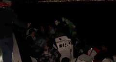 Kuşadası sahilinde Sahil Güvenlik ekipleri lastik botta yakalanan düzensiz göçmenleri kontrol ediyor