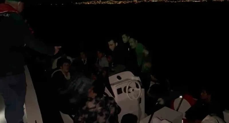 Kuşadası sahilinde Sahil Güvenlik ekipleri lastik botta yakalanan düzensiz göçmenleri kontrol ediyor