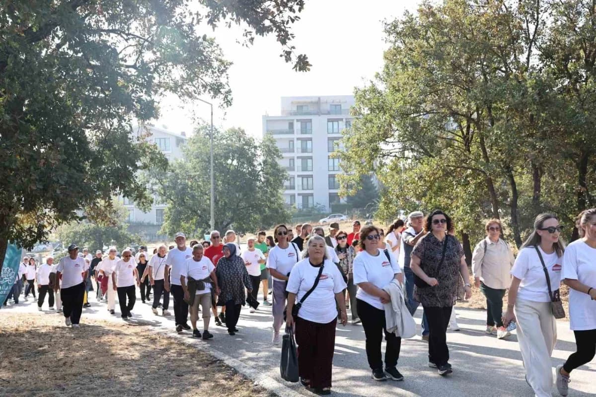 Nilüfer Belediyesi Alzheimer farkındalık yürüyüşü Balat Atatürk Ormanı’nda katılımcılar pankartlarla yürürken