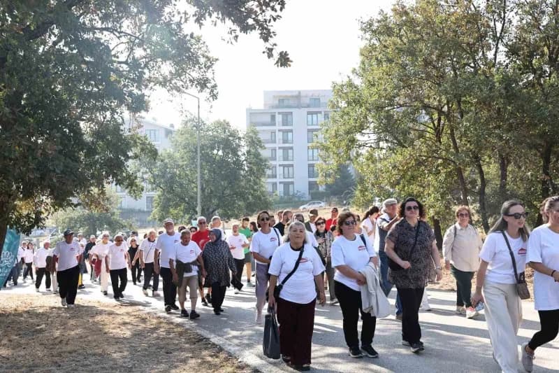 Nilüfer Belediyesi Alzheimer farkındalık yürüyüşü Balat Atatürk Ormanı’nda katılımcılar pankartlarla yürürken