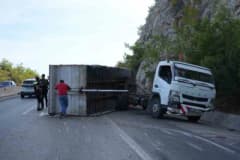 Antalya-Kemer karayolunda bariyerlere çarpan pelet yüklü kamyonun devrilen kasası ve yola saçılan peletler