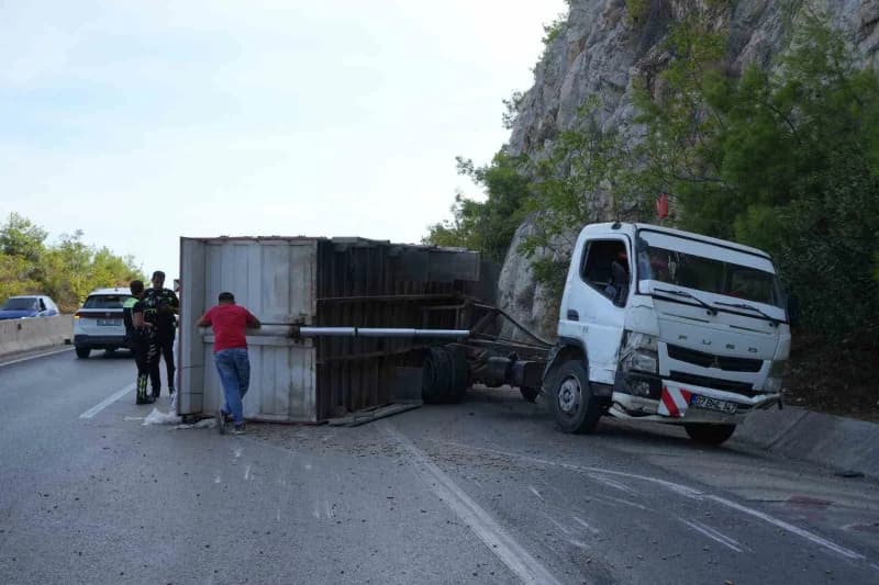 Antalya-Kemer karayolunda bariyerlere çarpan pelet yüklü kamyonun devrilen kasası ve yola saçılan peletler