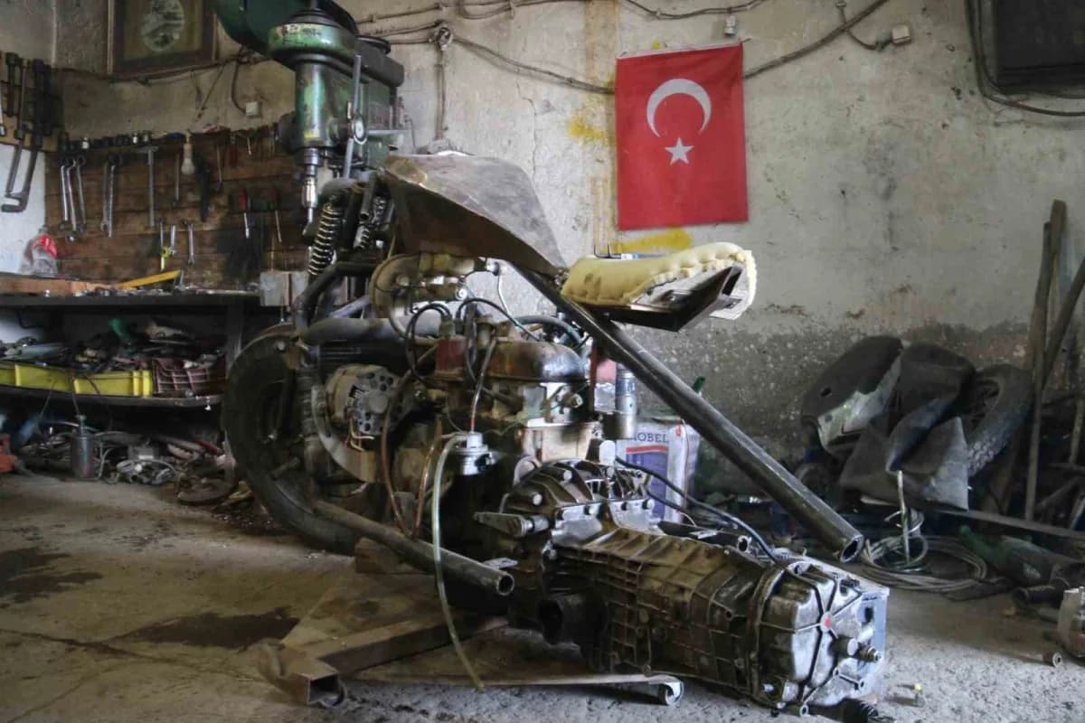 Sivas'ta genç Ahmet Yılmaz, otomobil motorundan yaptığı motosikletin iskeletini atölyede inceliyor