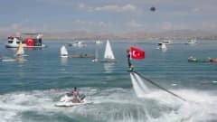 Van GölFest’te Türk bayrağı taşıyan flyboard gösterisi sırasında su üzerinde yükselen sporcu