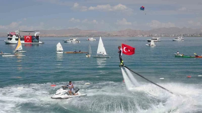Van GölFest’te Türk bayrağı taşıyan flyboard gösterisi sırasında su üzerinde yükselen sporcu