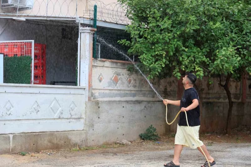 Üst kattan aşağıya düşen parçaların apartmanın alt katında bulunan markete sıçramaması için vatandaşlar hortumla müdahal