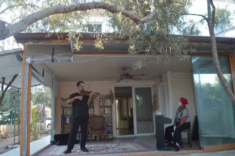 Ayvalık’ta bir evin bahçesinde zeytin ağacının gölgesinde gerçekleştirilen pandomim ve müzik performansı