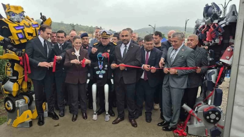 Robot kostümlü kişiler tarafından tutulan açılış kurdelesi, programa katılan protokol üyeleri ve robot Canik Men ile bir