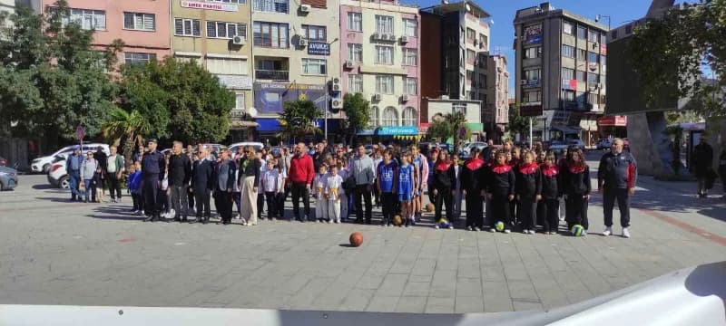Burhaniye'de Amatör Spor Haftası açılış töreninde sporcular ve katılımcılar çelenk sunuyor