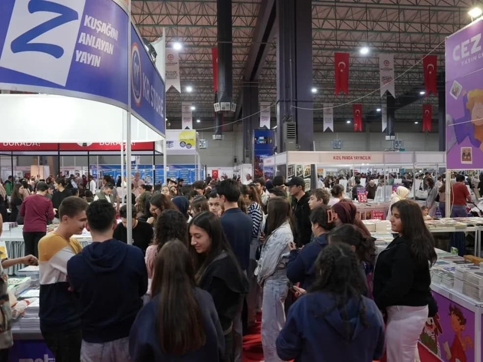 Denizli TÜYAP Kitap Fuarı'nda ziyaretçiler kitapları inceliyor ve etkinliklere katılıyor